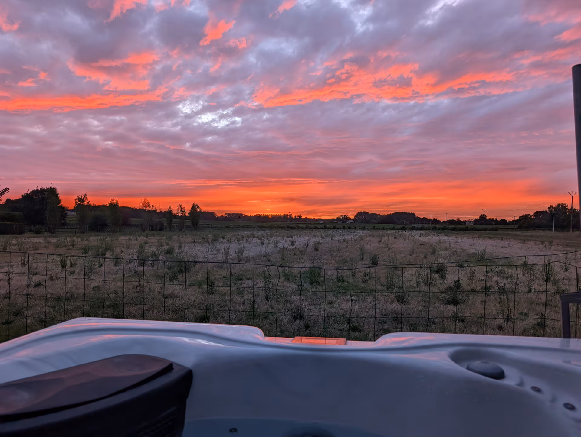 Coucher de soleil orange depuis la terrasse de la tiny house